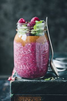 a jar filled with raspberry chia pudding and topped with fresh raspberries