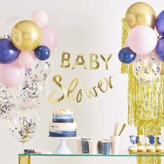 a baby shower party with balloons, cake and confetti on the side table