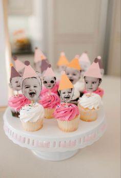 some cupcakes with faces on them are sitting on a cake plate in front of a mirror