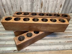 two wooden candlesticks sitting on top of each other in front of a wall