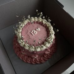 a pink cake with white frosting in a box