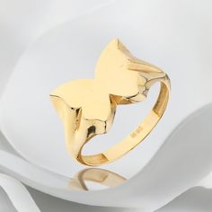 a close up of a gold ring with a butterfly on the front and back of it