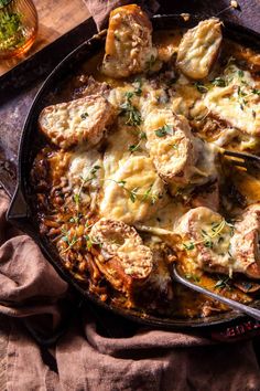 a skillet filled with meat and cheese covered in gravy