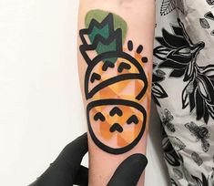 a person with a tattoo on their arm holding up a piece of fruit in the shape of a pineapple