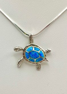 Solid .925 Sterling Silver Lab Opal Hawaiian Sea Turtle Honu Necklace. The size is 25MM, right about quarter sized. The Hidden bail is 6MM. FREE Italian Sterling Silver Snake Chain with lobster claw clasp Included in your choice of length.  -The Opal shifts dramatically from blue to green with hints of other hues in seemingly instantaneous flashes. Depending on your lighting these will be subtle to bright color changes. -The Hawaiian Turtle is the only indigenous reptile in the Islands. Symbols of the Turtle are often exchanged to signify strength, longevity and good luck.  -Packaged ready for gifting with a gift box, pouch, Sterling care instructions and a Hawaiian Honu story. *You can buy with confidence from us. Your happiness, satisfaction and living Aloha are our top priorities. Sea Turtle Hawaii, Hawaiian Turtle, Sea Turtle Jewelry, Hawaiian Sea Turtle, Hawaiian Necklace, Sea Necklace, Turtle Jewelry, Sea Jewelry, Silver Lab