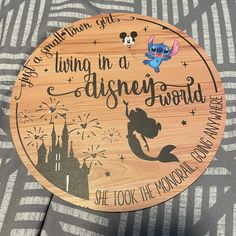 a wooden sign that says, living in a disney world she took the mouse's way