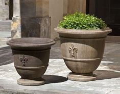 two cement planters sitting on the ground next to each other in front of a building