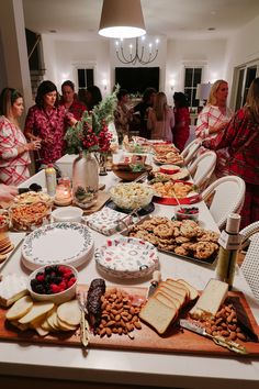 a group of women standing around a table filled with food