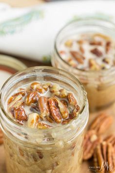 two mason jars filled with pecans on top of a wooden table next to other nuts