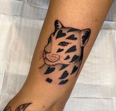 a tattoo on the leg of a person with a tiger head and hearts around it