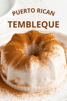 a cake covered in powdered sugar on a white plate with the words puerto rican tembleque above it