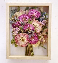 a bouquet of flowers in a wooden frame