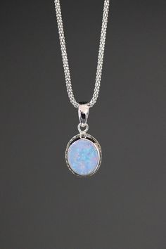 "An absolutely gorgeous smooth Blue Fire Opal oval stone is bezel set in a Bali Silver pendant. Please note the detail in the silver on the pendant.  This pendant may be purchased separately or with a silver chain. Please indicate desired length, 16\", 18\", 20\" or 24\". Chain style and clasp may vary slightly. Width of bail: 5mm Blue Fire Opal bezel: 11x13mm Bali Silver pendant: 12x25mm (including bail at the top) Total length of pendant: almost 1\" All silver is sterling. As the owner, maker, Silver Sapphire Oval Pendant Jewelry, Opal Necklace Vintage, Magical Blue Pendant Jewelry, Womens Necklaces Silver, Blue Opal Pendant Jewelry, Blue Opal Round Pendant Jewelry, Nickel-free Blue Oval Pendant Jewelry, Blue Fire Opal, Blue Opal Necklace