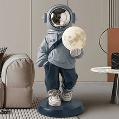 a small statue of an astronaut holding the moon in his hand and looking at it