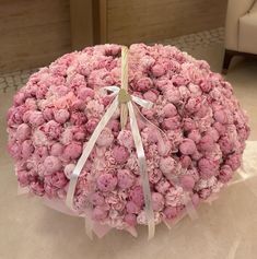 a large bouquet of pink flowers with white ribbons