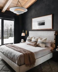 a bedroom with black walls, white bedding and wooden ceiling beams in the corner