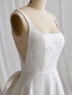 a white dress on a mannequin dummy with the back cut out and beading