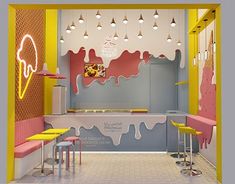 an ice cream shop with yellow stools and pink counter tops, painted in bright colors