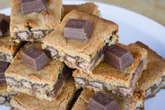 a white plate topped with lots of cookies and chocolate bars on top of each other