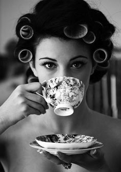 a woman drinking from a coffee cup with curly hair on her head and the words all things are possible with coffee and mascara