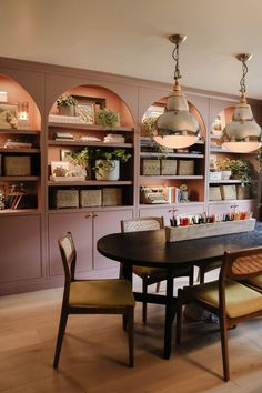 the dining room table is surrounded by built in bookshelves and shelving units