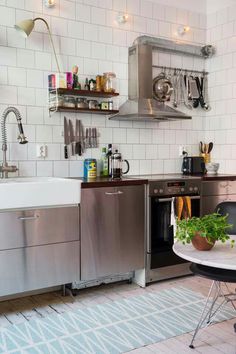 a kitchen with stainless steel appliances and white tiles on the walls is pictured in this image