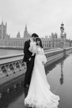 a bride and groom pose for a photo in front of the palace