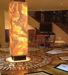 the lobby is decorated in marble and features an artistic floor design that matches with the staircase