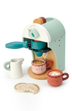 a toy coffee maker with two cups next to it