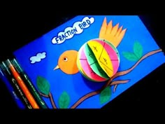 an orange bird on a blue background with crayons next to it