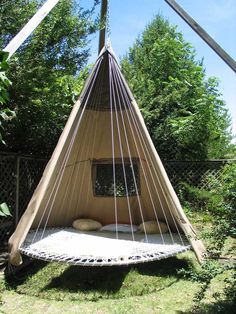 an image of a bed made out of a hammock hanging from a pole