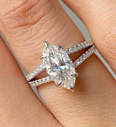 a woman's hand with a diamond ring on top of her finger and an engagement band