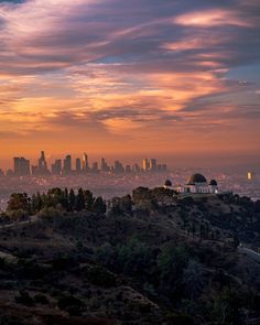 the city skyline is seen in the distance as the sun sets over los angeles, california