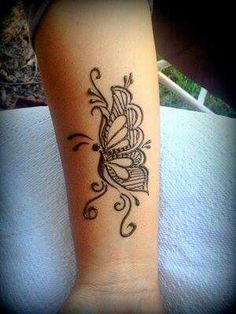 a butterfly tattoo on the arm and leg, with an intricate design in black ink