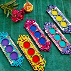 four different colored frames sitting on top of a green table cloth next to flowers and a vase