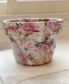 a flower pot sitting on top of a white table next to a window sill