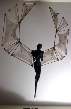 a sculpture of a man holding an umbrella on top of a table in front of a white wall