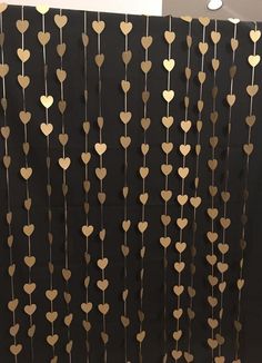 some gold hearts hanging from the side of a wall