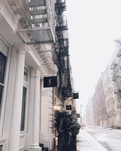 an old building on the side of a street with fire escape ladders hanging from it's sides