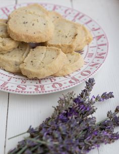 cookies and lavender on a plate next to a flower