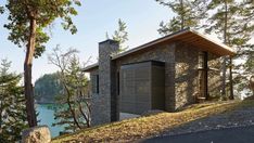 a small building sitting on top of a hill next to a lake