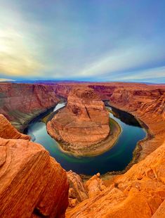 a lake in the middle of a canyon surrounded by red rocks and orange rock formations