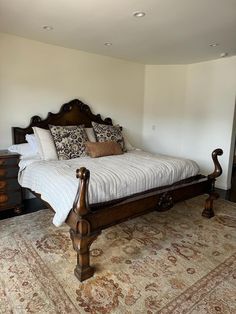 a large bed sitting in the middle of a bedroom on top of a carpeted floor