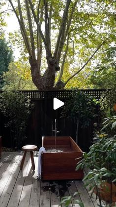 an outdoor bathtub in the middle of a wooden deck with potted plants on it