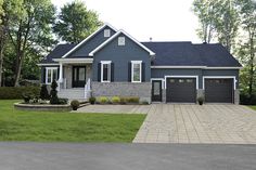 a blue house with two garages in the front yard