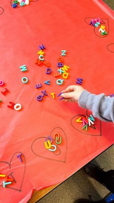 a little boy that is standing in front of a table with some letters on it