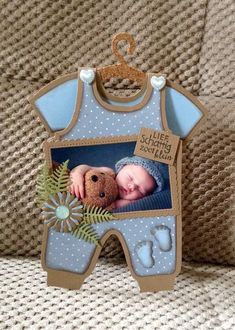 a baby's photo hanging on the back of a couch with a teddy bear