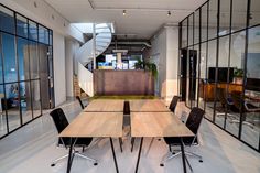 an empty conference room with tables and chairs in front of large glass windows that look out onto the outdoors