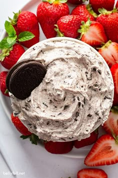 an oreo cookie and cream dip on a plate with strawberries