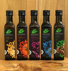 four bottles of extra virgin olive oil on a wooden table